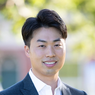 Dentist Henry Hur Smiling Outdoors In Front Of Blurred Background
