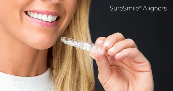 Hand Holding SureSmile Clear Aligner In Front Of Their Carrying Case